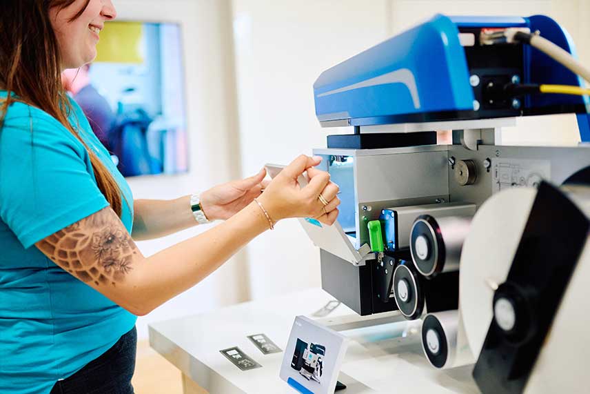 ACI Mitarbeiterin demonstriert das Folienhandlingsystem Foil Star für die Laserbeschriftung