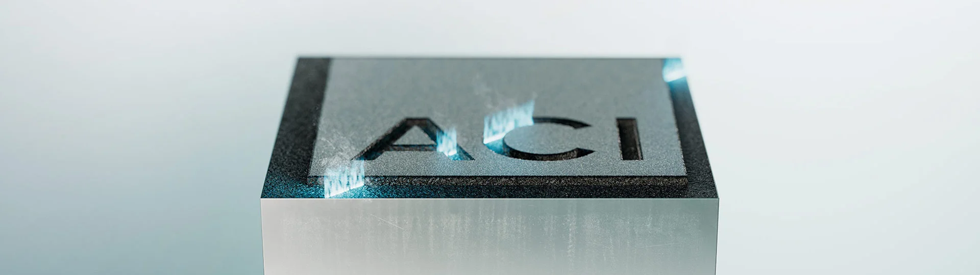 Gravierter Metallblock mit ACI Laser Logo - Symbol für Präzision und Qualität